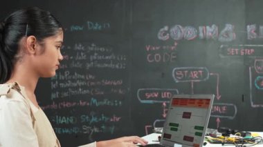 Liseli kız BTMM Teknoloji dersine katılırken hemen kod ya da mühendislik dersi alıyor. Tahtanın önündeki bilgisayar ekranına bakarken ergen kodlaması ya da programlama sistemi. Öğretim