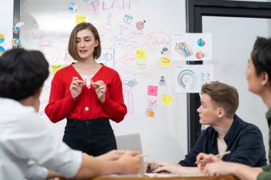 Profesyonel çekici kadın lider, modern iş toplantı odasında beyin fırtınası zihin haritalama istatistikleri ve renkli yapışkan notlar kullanarak yaratıcı pazarlama planını sunuyor. Tertemiz..