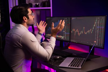 Akıllı tüccar işadamı, karanlık oda gecesinde neon ışıklı ofisteki arama pazarında yüksek kârla ekranda bilgisayar ve bilgisayar üzerinde dinamik borsa yatırımları üzerinde yoğunlaşıyor. Tahmin et..