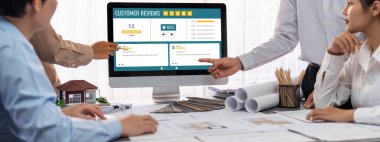 İç mimar tasarımcı grubu, daha kesin tasarım için planlar ve dizüstü bilgisayar ekran mimari yazılımı üzerinde birlikte tartışıyorlar. Modern ev tasarımı ve yenileme. İçgörü