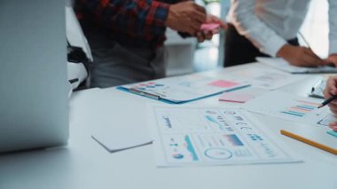 Pazarlama fikirlerini yenilemek ve stratejik kararları iyileştirmek için anahtar iş ölçümlerini analiz eden bir danışman ve bir yapay zeka asistanının yer aldığı modern bir ofis toplantısı. Noogenesis Yapay Zeka