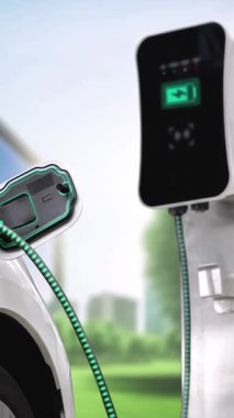 Yeşil Şehir Parkı 'ndaki ekolojik temiz enerji şarj istasyonundan gelen fütürist akıllı EV şarj aletinin şarj ettiği elektrikli araba. Alternatif enerji kullanan gelecekçi elektrikli araba. İnceleyin