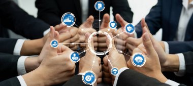 Bu resim, yönetim alanında takım çalışmasını ve işbirliğini sembolize eden, başparmak kaldıran çeşitli bir grubu tasvir eder. Çevrelerinde dijital simgeler var, çeşitli iş kavramlarını temsil ediyorlar. Dostluk