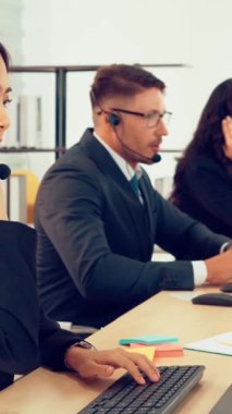 Ofiste çalışan kulaklık takan işadamları uzak müşteri ya da meslektaşlarını desteklemek için çalışıyorlar. Arama merkezi, tele pazarlama, müşteri destek acentesi telefon görüşmesinde hizmet sunar.
