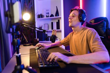 Kazanmak için çevrimiçi oyun oynayan akıllı flama makinesinin sunucu kanalı, neon ışıklı odada seçilen takım yarışması için izleyicilerle birlikte canlı yayında canlı yayında kulaklık takıyor. Bireysel.