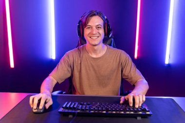 Kazanmak için çevrimiçi oyun oynayan akıllı flama makinesinin sunucu kanalı, neon ışıklı odada seçilen takım yarışması için izleyicilerle birlikte canlı yayında canlı yayında kulaklık takıyor. Bireysel.