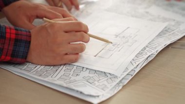 Mimari ekipmanlarla toplantı masasında ev tasarımı üzerine profesyonel mühendis ekibi tartışması ve modern ofiste bina planı dağılımı. Eline odaklan. - Yakın çekim. Tanımlama.