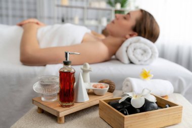 Aromaterapi masajı gündüz atmosferinde ya da spa salonunda bulanık bir kadına odak dekor ve spa aksesuarları kurarak tatil köyünde ya da otel arka planında keyifli aroma spa masajı yapan bir masaj. Sessiz.