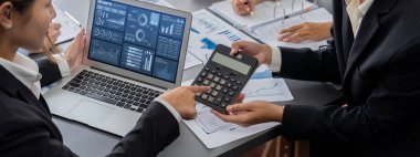 İş zekası ve veri analizi kavramı. Analizci ekibi laptop ekranında finansal veri analizi üzerinde çalışıyor. Etkili iş stratejik planlama için pazarlama göstergesi olarak. İçgörü