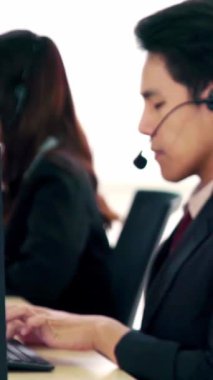 Ofiste çalışan kulaklık takan işadamları uzak müşteri ya da meslektaşlarını desteklemek için çalışıyorlar. Arama merkezi, tele pazarlama, müşteri destek acentesi telefon görüşmesinde hizmet sunar.