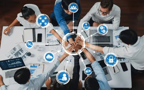 Çeşitli iş adamları, yenilik ve verimliliği artırmak için strateji tartışmaları ve dijital bağlantılarla ilgilenerek, modern bir çalışma alanı etrafında işbirliği yaparlar. Dostluk