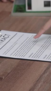 Gayretli emlak acentesi müşteriye bir emlak acentesi tarafından tavsiye edilirken, ev kredisi için müşteri sözleşmesi belgelerini sunar..