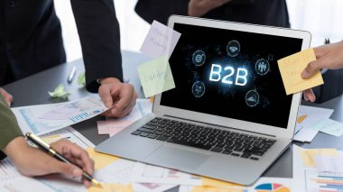 İş adamı B2B peyzajında geziniyor, iş-iş bağlantılarını geliştirmek için kullanım teknolojisi kullanıyor. B2B etkileşimini yeniden şekillendiren keşifler, iş-iş stratejilerinde yenilikleri yönlendiren araçlar. canlı