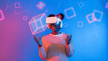 VR gözlüklü Afrikalı kız mavi ve pembe arka planda duruyor ve yüzen geometrik şekle bakıyor. Heyecanlı insan görsel gerçeklik dünyasına giriyor. Teknoloji yeniliği. Yaratıcılık.