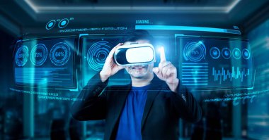 VR gözlüklü bir proje yöneticisi mali tabloyu ve ofisteki parlak mavi ışığı gösteriyor. Yetenekli iş adamı artırılmış gerçeklikten elde edilen verileri kullanarak pazarlama stratejisini kontrol edip planlıyor. Yaratıcılık.