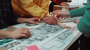 Değişik ellerin aktif olarak ortak bir planlama oturumuna katıldığı canlı renk örnekleri ve malzemelerle çevrili bir kat planı çizen dinamik bir sahne. SACTR