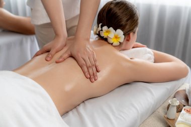 Kafkas çift müşterisi stres önleyici spa masajının keyfini çıkarıyor ve lüks otel veya oteldeki gündüz açık hava ortamında güzellik teniyle eğleniyor. Sessiz.