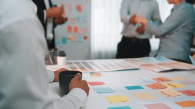 Yapışkan notlarla tartışan ve beyin fırtınası yapan bir takımı tasvir eden dinamik bir ofis. Sahne işbirliği ve yaratıcı fikir oluşumunu yakalıyor. SACTR