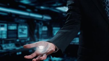 Bir işadamı, dijital çağda büyümeyi ve yaratıcılığı yansıtan, modern bir çalışma alanında eğitim, yenilik ve teknolojiyi sembolize eden yüzen ikonlar sunar. Dörtgen