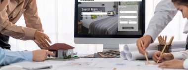 İç mimar tasarımcı grubu, daha kesin tasarım için planlar ve dizüstü bilgisayar ekran mimari yazılımı üzerinde birlikte tartışıyorlar. Modern ev tasarımı ve yenileme. İçgörü