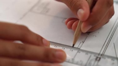 Ölçüm aracı ve kalem el kullanan akıllı mimar veya akıllı mühendisin videosu mimari ofisteki inşaat hatasızlığı için ayrıntılı bir tasarım hazırladı. Eline odaklan. - Yakın çekim. Tanımlama.