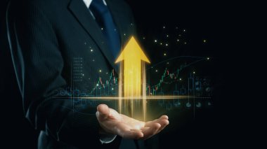 Bir işadamı avucundaki büyümeyi simgeleyen parlak bir ok sunuyor, finansal tabloların ve parlayan parçacıkların bir zeminine karşı dizilmiş, başarı ve yatırım potansiyelini gösteren. Dörtgen