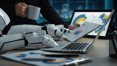 Renkli çizelgeleri olan bir dizüstü bilgisayardaki verileri analiz eden modern bir çalışma alanı. Yakınlarda bir kahve fincanı. Teknoloji ve iş dünyasındaki yenilikleri somutlaştıran.