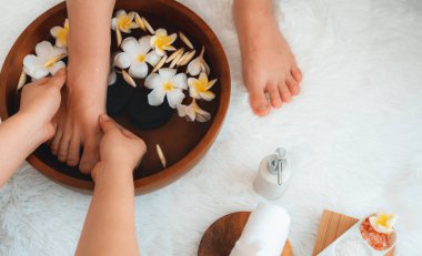 Kadınlar lüks spa salonlarında keyifli ayak masajlarına devam ederken, masör de hafif gün ışığı atmosferinde refleksoloji terapisi veya otel ayak spa 'sında. Sessiz.