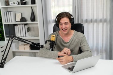 Sunucu kanalı, gülümseyen akıllı yayıncı kaydı, senaryosu ve akıllı telefonuyla sosyal medyada sohbet programı, kulaklık takarak modern ev stüdyosundaki video flamalarını kaydediyor. Bireysel.