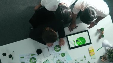 Yenilenebilir enerji hakkında tartışan iş ekibinin aşağı görüşü. Masada dizüstü bilgisayar kullanırken sıfır atık hakkında plan yapmak için birlikte çalışan yetenekli iş adamlarının hava görüşü. Hizalama.