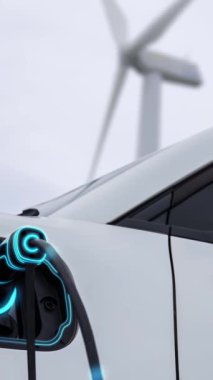 Elektrikli araba, rüzgar türbini çiftliğinde çalışan akıllı EV şarj cihazıyla şarj edilen enerjiyi şarj ediyor. Alternatif temiz sürdürülebilir enerjinin teknolojik ilerlemesi. İnceleyin