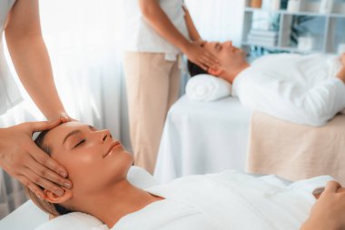 Kafkasyalı çift stres önleyici kafa masajının keyfini çıkarıyor ve lüks otellerde ya da otel spa salonlarında gündüz kaplıcalarında yüz güzelliği eğlencelerini şımartıyor. Sessiz.