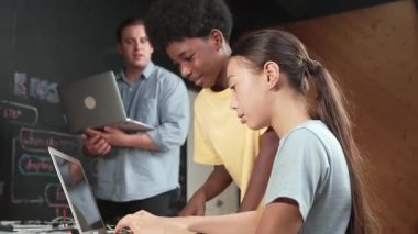 Çeşitli öğrencilerden oluşan bir grup program yazmak için birlikte çalışıyor. Öğretmenler BTMM dersindeki hata noktasını açıklarken çok kültürlü çocukların kodlaması ya da programlaması. Öğretim