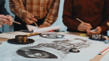 Çeşitli bir ekip, yenilikçi fikirler geliştirmek için modern bir çalışma alanında teknik çizimleri ve tasarım araçlarını tartışan bir mühendislik projesinde işbirliği yapıyor. SACTR