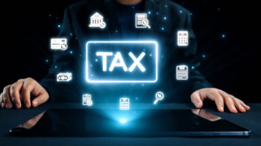 Bir işadamı, parlayan finansal simgelerle çevrili, vergi idaresi için dijital tablet kullanır. Bu görüntü, teknolojinin modern finansal süreçlere entegrasyonunu temsil ediyor. Dörtgen