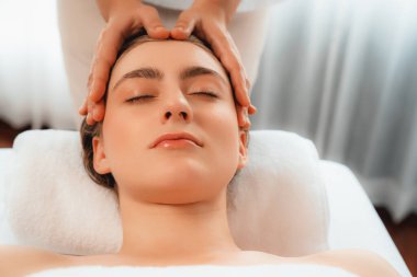 Kafkasyalı kadın stres önleyici kafa masajından ve lüks tatil beldesi ya da otel spa salonundaki modern ışık ortamında yüz güzelliği eğlencelerini şımartmaktan hoşlanıyor. Sessiz.