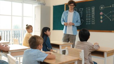 Kafkas öğretmeni matematik dersinde tahtaya cevap yazmak için gönüllü buldu. Öğretmen, öğrenciye tebeşir verilirken ve sınıfın önünde yürürken soruyu cevaplamak için gönüllü olmayı talep ediyor. Pedagoji.