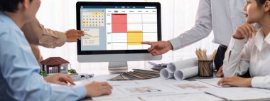 İç mimar tasarımcı grubu, daha kesin tasarım için planlar ve dizüstü bilgisayar ekran mimari yazılımı üzerinde birlikte tartışıyorlar. Modern ev tasarımı ve yenileme. İçgörü