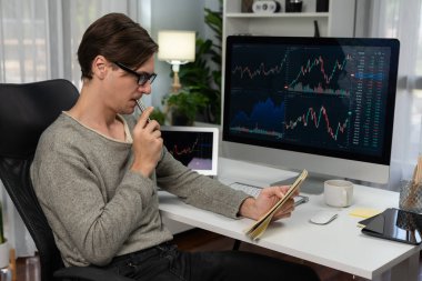 Gündelik işlerde çalışan zeki bir tüccar, dinamik yükseltilmiş borsa grafiğinin kar değerini analiz ederek, modern ofisteki kârlı yatırım listesi için kağıt üzerinde not alıyor. Bireysel.