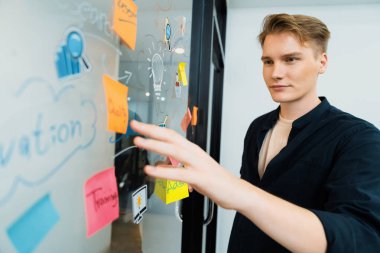 Kafkasyalı profesyonel iş adamının zihin haritası ve renkli yapışkan notlar kullanarak iş pazarlama fikrini kendine güvenle sunuşunun yakın görüntüsü. Proje konseptini başlat. Portre. Tertemiz..