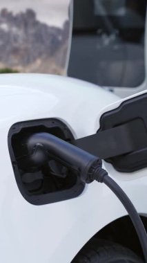 Elektro jeneratör sürücüsüyle enerji sürdürülebilir araba gücü, şarj istasyonunda şarj edilen batarya, ilerici seyahat konsepti için dağ zeminine sahip. Temiz ortamın sembolü olarak doğadaki EV otomobil.