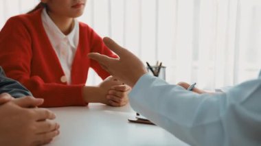 Çift, kısmen hamilelik planlaması için hastanede jinekologla doğum danışmanlığına gidiyor. Karı ve koca doktor randevusu boyunca dikkatle dinlerler. Ağır çekim. Katı.