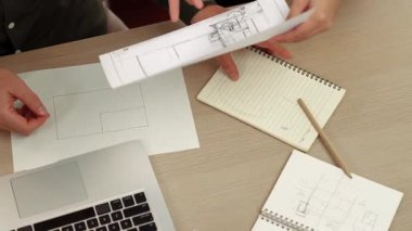 Akıllı mimar ve akıllı mühendisin dizüstü bilgisayarlı videosu mimarlık bürosundaki inşaat isabet planı hakkında tartışıyorlar. Eline odaklan. - Yakın çekim. Tanımlama.