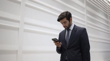 Yetenekli yönetici, iş arkadaşıyla proje hakkında konuşmak için telefon görüşmesi yapıyor. Yakışıklı erkek lider, ayakta durup kameraya bakarken satış hakkında konuşmak ve rapor vermek için iş ekibini arıyor. Sevinçli..