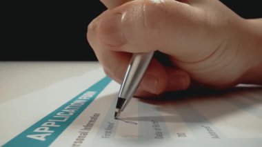 İş başvuru formu belgesine kişisel bilgileri dolduran ve isim yazan başvuru sahiplerinin yakın çekim makro çekim hareketi. İşsiz aday için istihdam ve iş olanağı.