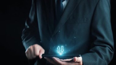 Takım elbiseli bir işadamı, modern iş stratejileri ve analizleri sembolize eden büyüleyici dijital kalite ve maliyet göstergelerine sahip bir akıllı telefon tutuyor. Dörtgen