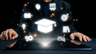 Bu dijital öğrenme kavramında eğitim ve teknolojinin kaynaşmasını keşfedin, bir tablet cihazını çevreleyen bir mezuniyet şapkası ve çeşitli bilgi simgeleriyle birlikte. Dörtgen