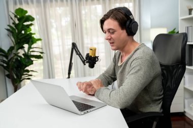 Sunucu kanalı, gülümseyen akıllı yayıncı kaydı, senaryosu ve akıllı telefonuyla sosyal medyada sohbet programı, kulaklık takarak modern ev stüdyosundaki video flamalarını kaydediyor. Bireysel.