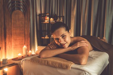 Beyaz kadın müşteri stres önleyici spa masajının keyfini çıkarıyor ve lüks otel ya da otelde sıcak mum ışığında güzellik teniyle eğleniyor. Sessiz.