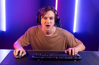 Kazanmak için çevrimiçi oyun oynayan akıllı flama makinesinin sunucu kanalı, neon ışıklı odada seçilen takım yarışması için izleyicilerle birlikte canlı yayında canlı yayında kulaklık takıyor. Bireysel.